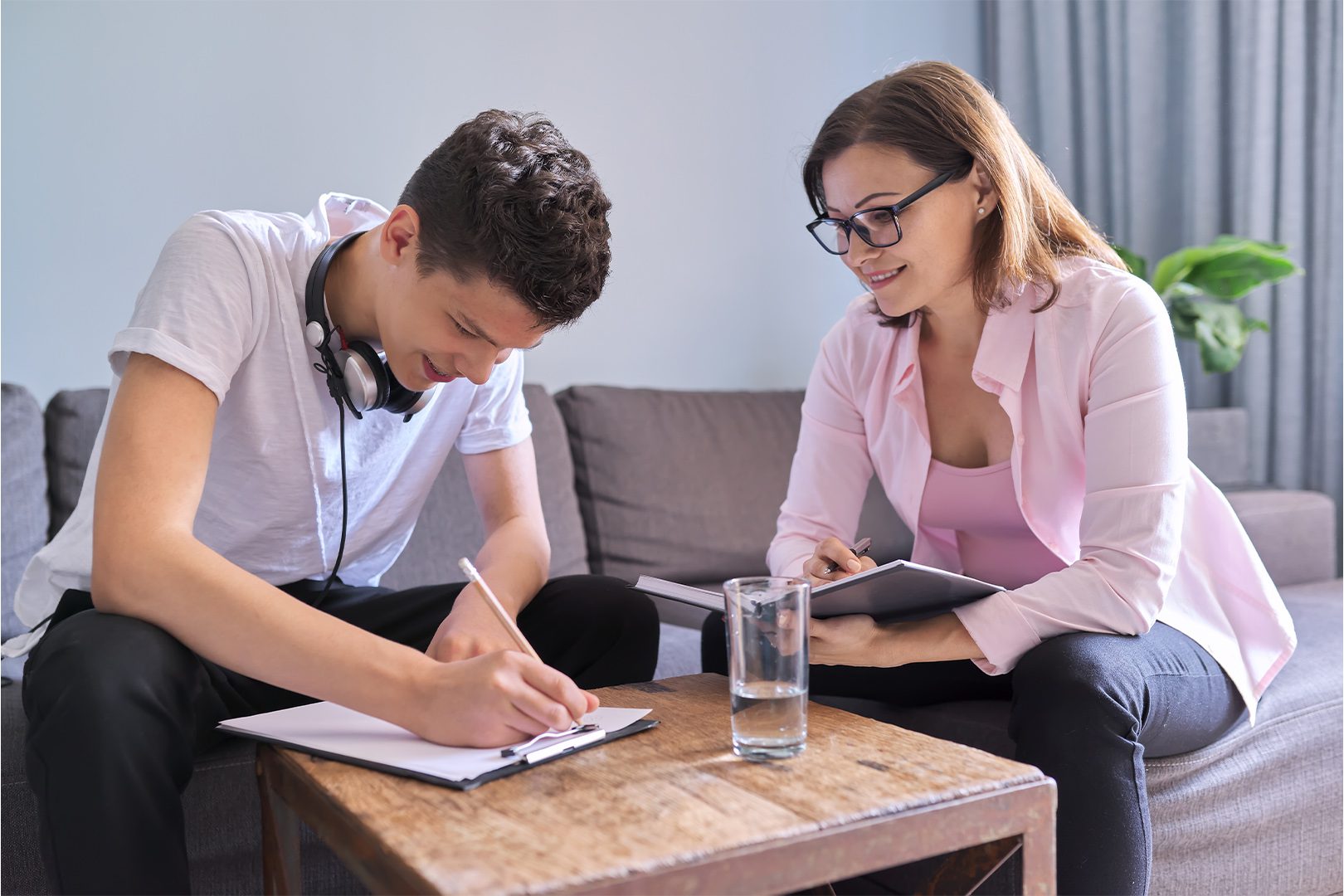 Boy teenager gives interview to woman psychologist in office, college student at consultation